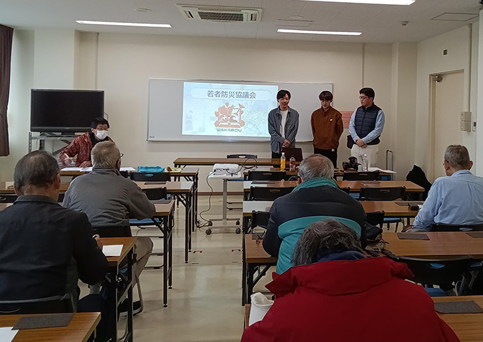 防災訓練で説明する若者